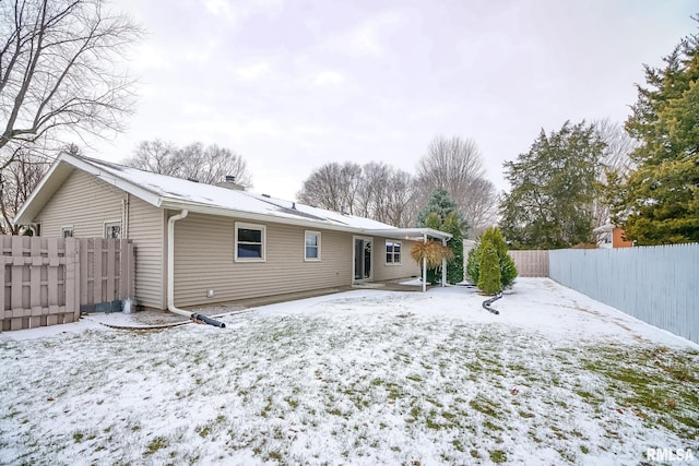 view of snow covered rear of property