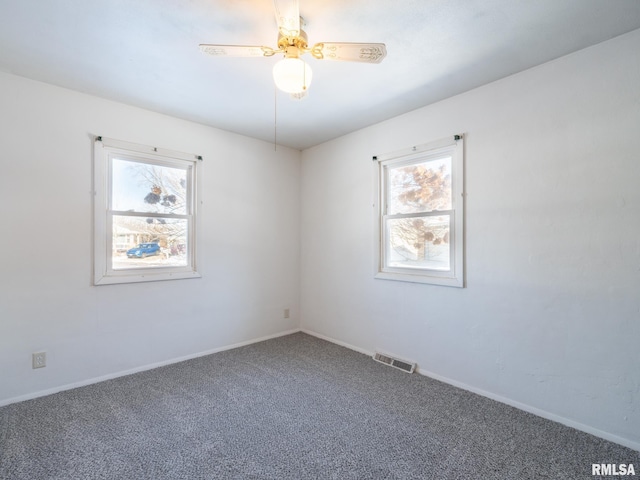 empty room featuring carpet, ceiling fan, and a healthy amount of sunlight