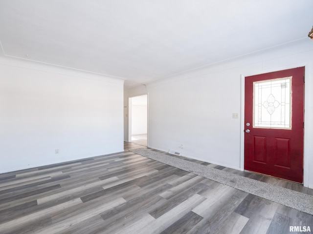 entryway with ornamental molding and hardwood / wood-style flooring