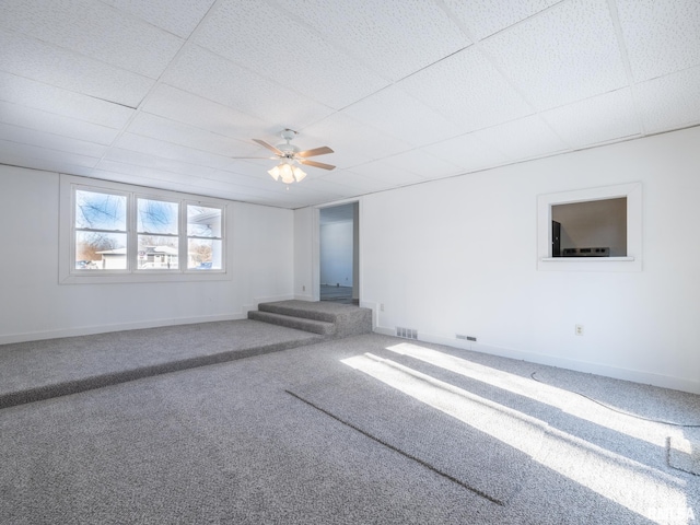 spare room featuring carpet flooring, a drop ceiling, and ceiling fan