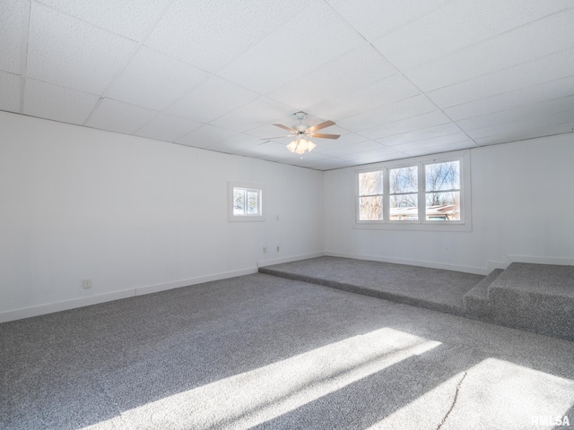 unfurnished room with carpet, a drop ceiling, and ceiling fan