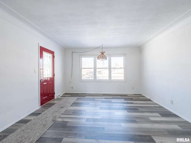 empty room with crown molding and dark hardwood / wood-style floors