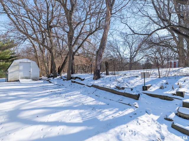 yard layered in snow with an outbuilding