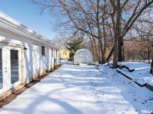 yard covered in snow with a shed