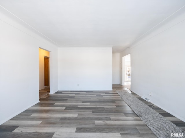 spare room featuring dark hardwood / wood-style flooring and ornamental molding