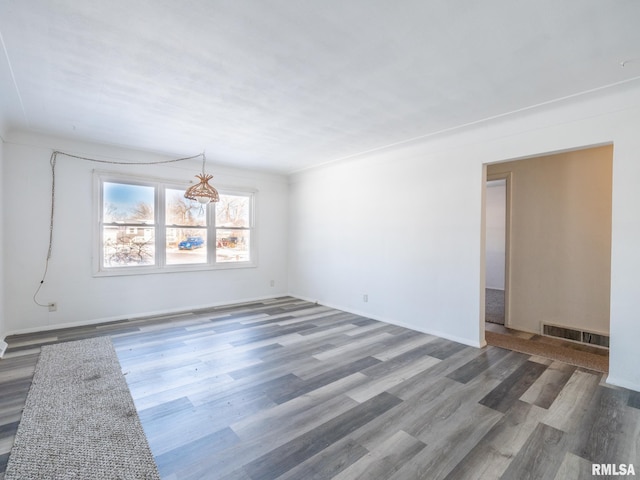 empty room featuring hardwood / wood-style floors and ornamental molding