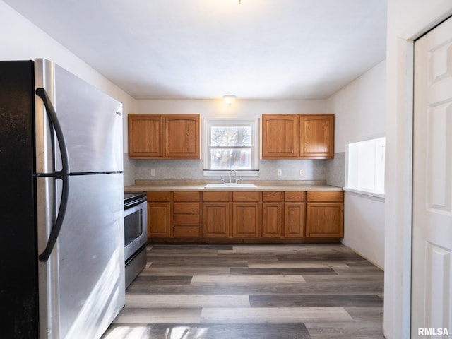 kitchen with decorative backsplash, sink, appliances with stainless steel finishes, and dark wood-type flooring