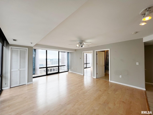 empty room with ceiling fan and light wood-type flooring