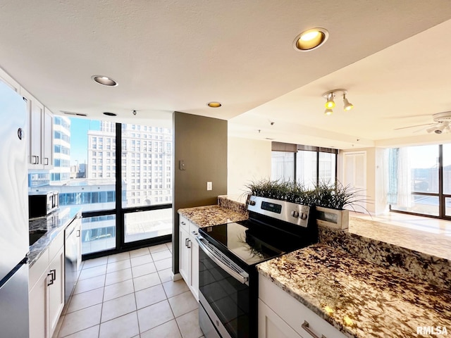 kitchen with white cabinets, light stone countertops, and stainless steel appliances