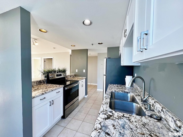 kitchen featuring light stone countertops, sink, stainless steel appliances, light tile patterned floors, and white cabinets