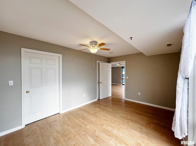 unfurnished bedroom with ceiling fan and light wood-type flooring