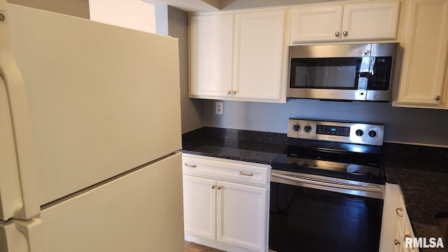 kitchen featuring dark stone counters, white cabinets, and stainless steel appliances