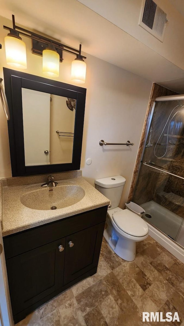 bathroom featuring vanity, toilet, and an enclosed shower