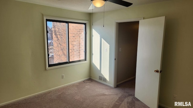 carpeted empty room with ceiling fan and a healthy amount of sunlight