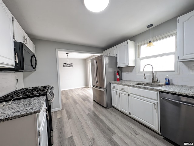 kitchen featuring white cabinets, decorative backsplash, sink, and appliances with stainless steel finishes