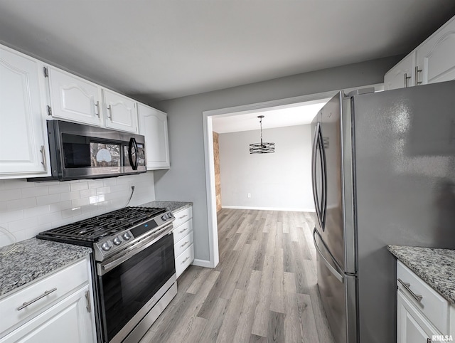 kitchen with stone countertops, tasteful backsplash, decorative light fixtures, white cabinetry, and stainless steel appliances