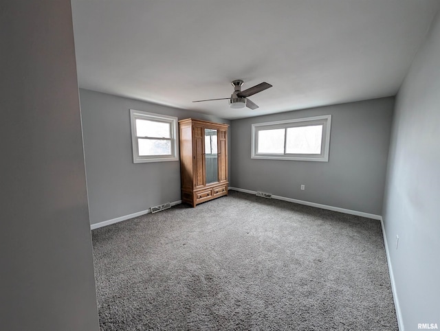 empty room with ceiling fan and carpet floors