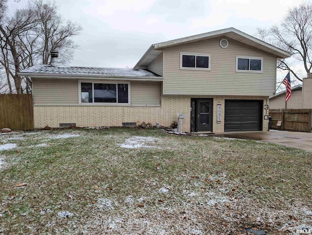 tri-level home featuring a front lawn and a garage