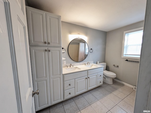 bathroom with tile patterned floors, vanity, and toilet