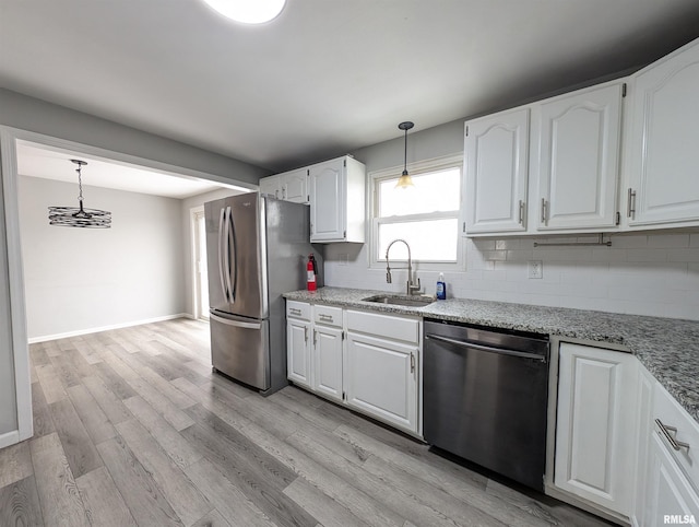 kitchen with white cabinets, sink, tasteful backsplash, decorative light fixtures, and stainless steel appliances