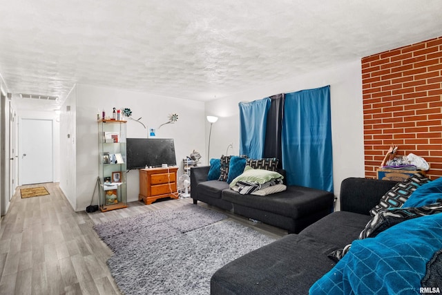 living room featuring light hardwood / wood-style floors and a textured ceiling