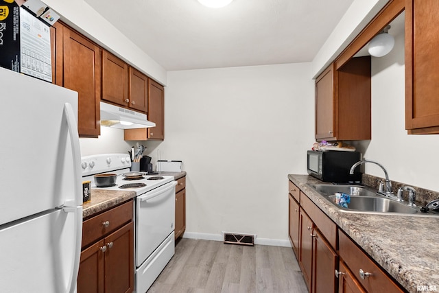 kitchen featuring sink, white appliances, and light hardwood / wood-style flooring