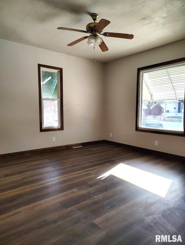 unfurnished room featuring ceiling fan, dark wood-type flooring, and a textured ceiling