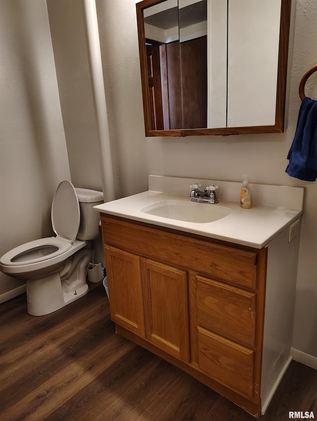 bathroom featuring vanity, hardwood / wood-style flooring, and toilet