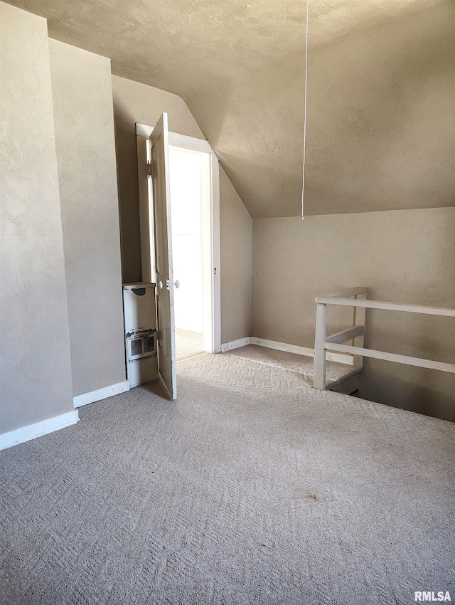 bonus room with carpet flooring and vaulted ceiling