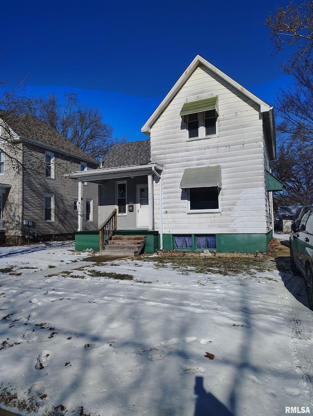 view of snow covered back of property