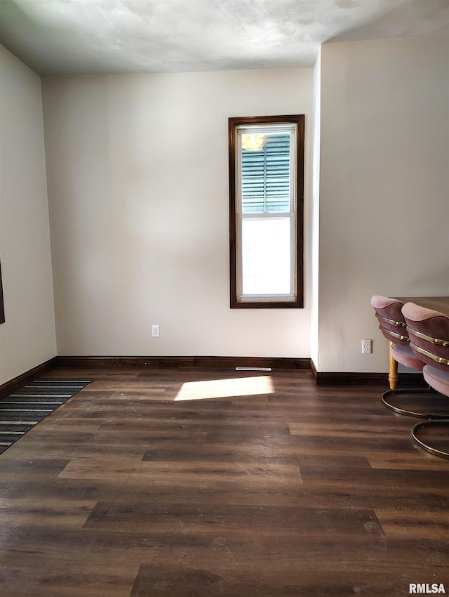 empty room with dark wood-type flooring