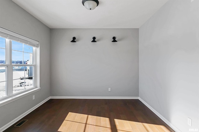 spare room with dark wood-type flooring