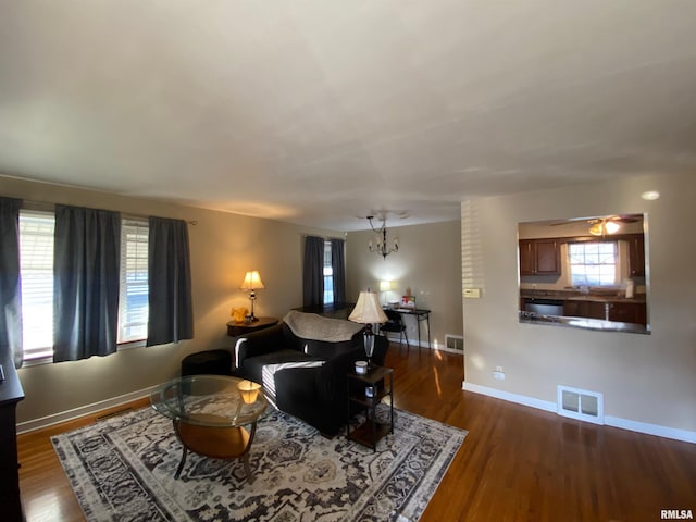 living room with dark hardwood / wood-style floors and a notable chandelier