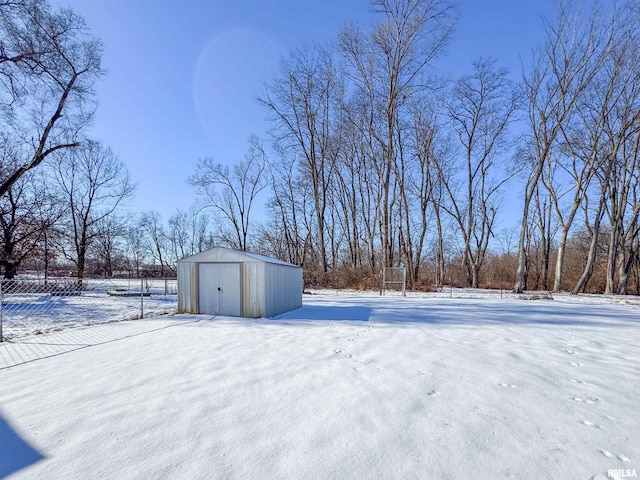 yard layered in snow featuring a storage unit