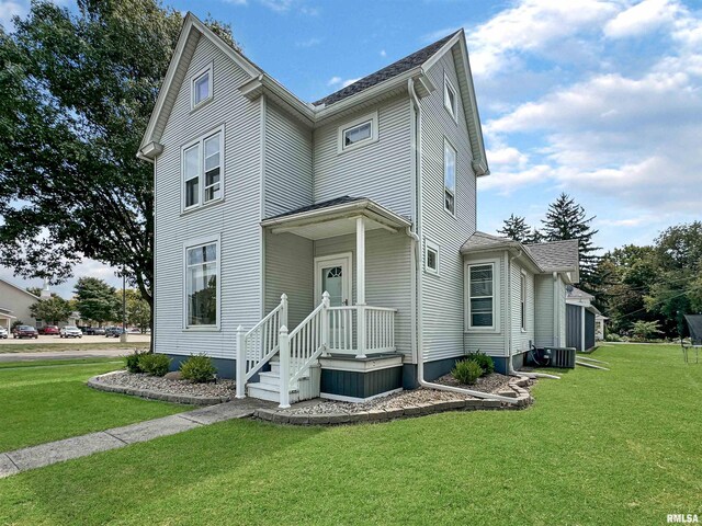 view of front of property featuring central air condition unit and a front yard