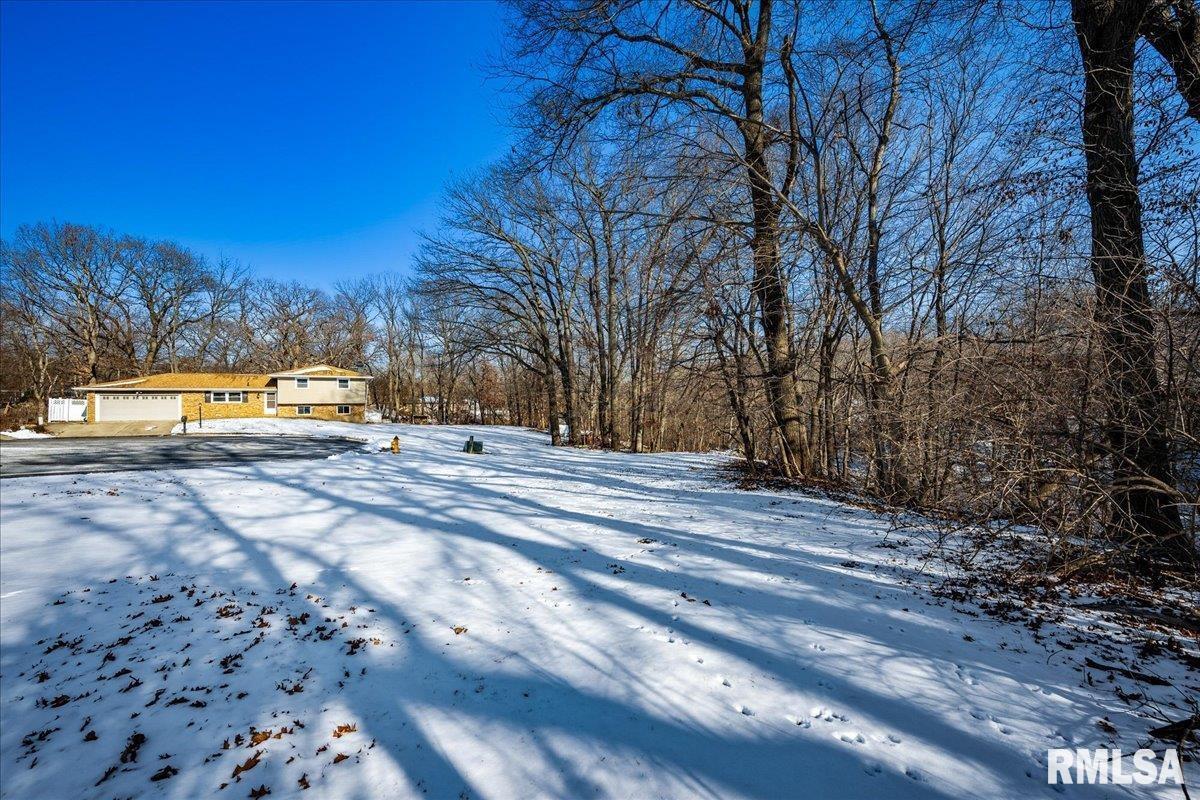 snowy yard featuring a garage