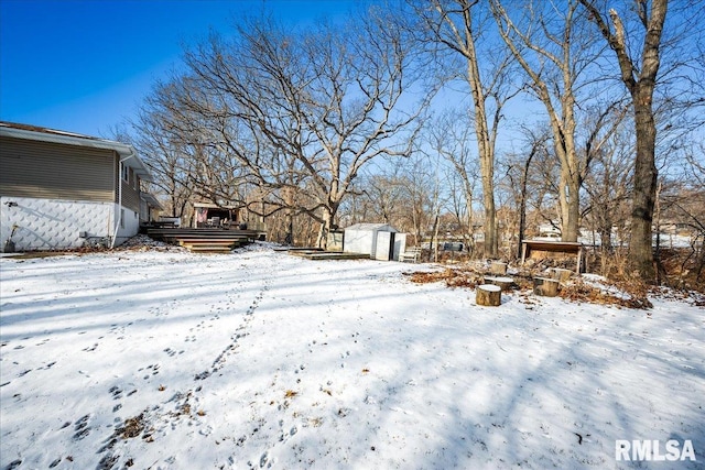 yard covered in snow featuring a storage shed