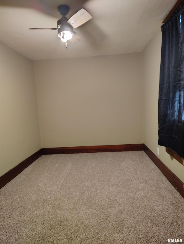 carpeted empty room featuring a ceiling fan and baseboards