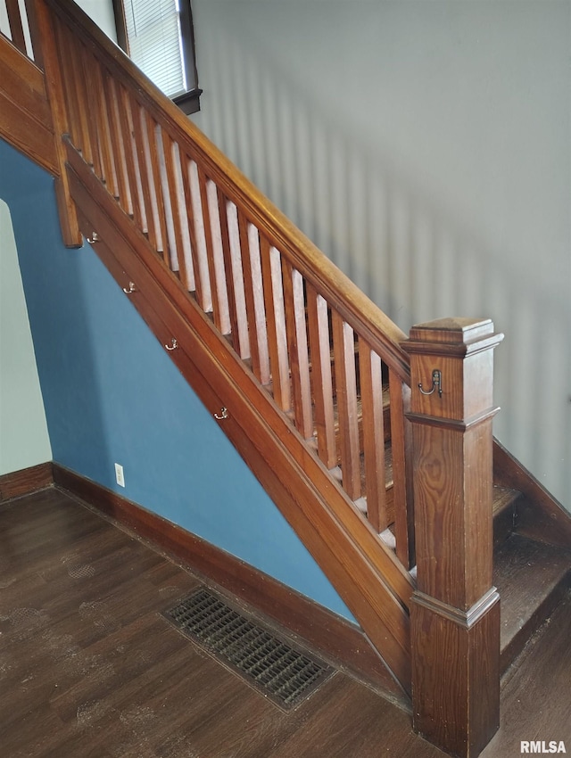 stairway featuring wood finished floors, visible vents, and baseboards