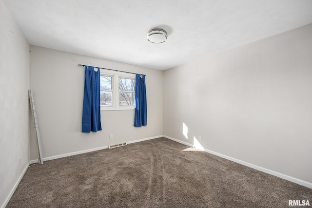 spare room featuring dark carpet