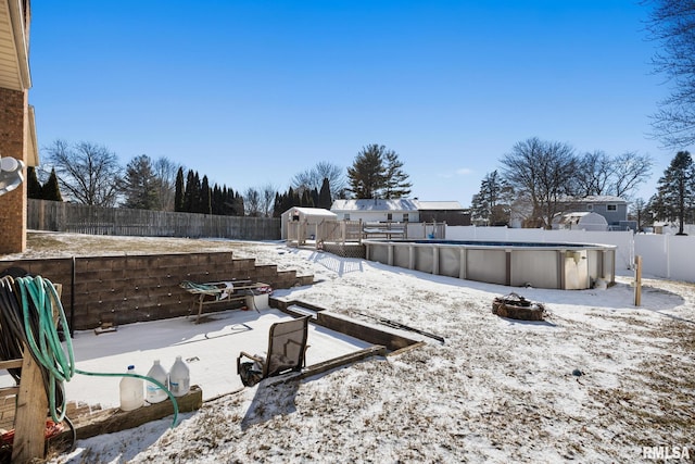 yard covered in snow featuring a fenced in pool