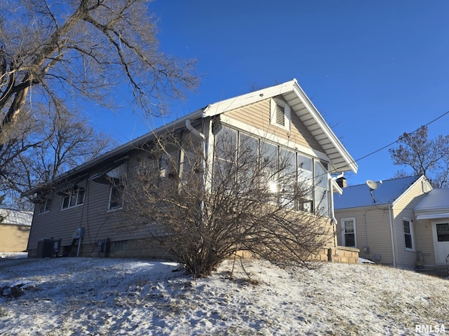 view of snowy exterior with central AC unit