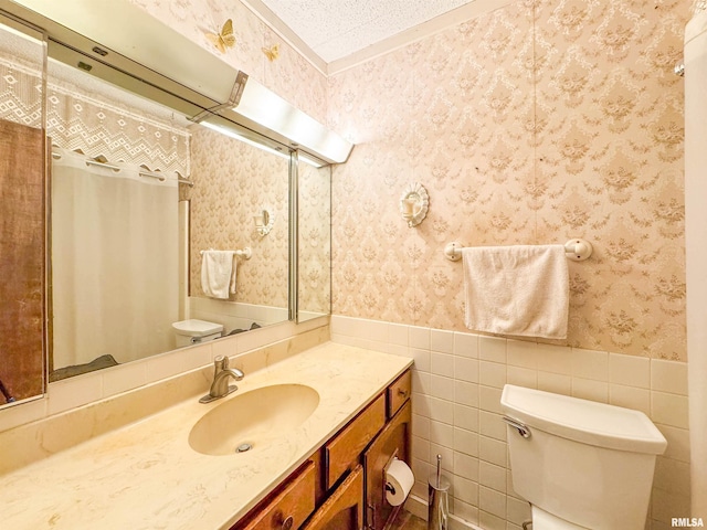 bathroom with tile walls, toilet, and vanity