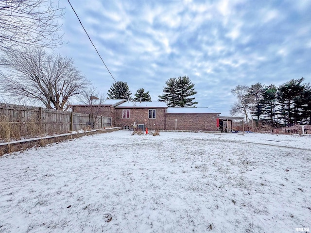 view of snow covered rear of property