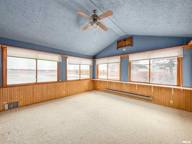 unfurnished sunroom featuring ceiling fan, a healthy amount of sunlight, a baseboard radiator, and lofted ceiling