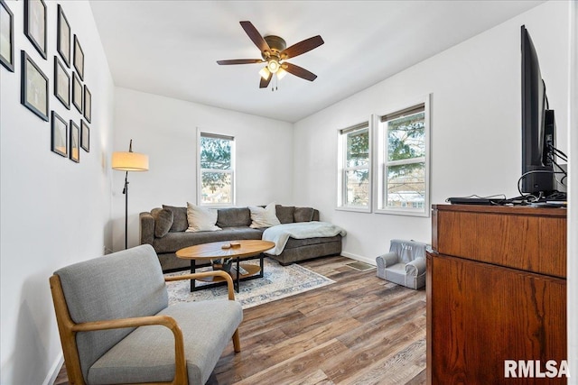 living room featuring wood-type flooring, ceiling fan, and a healthy amount of sunlight