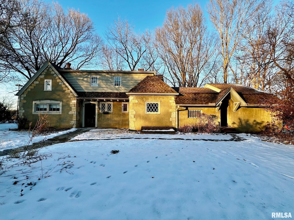 view of front facade featuring stone siding and a chimney