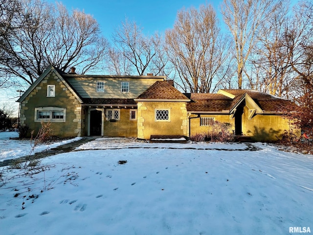 view of front facade featuring stone siding and a chimney