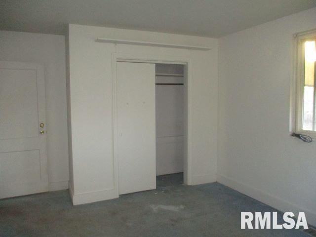 unfurnished bedroom with a closet and multiple windows