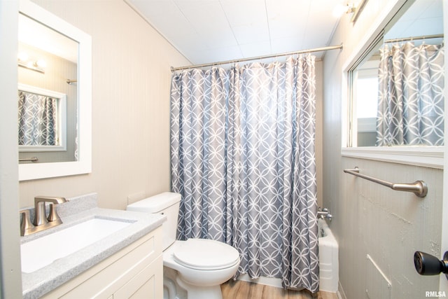 full bathroom with hardwood / wood-style flooring, shower / bath combination with curtain, vanity, and toilet